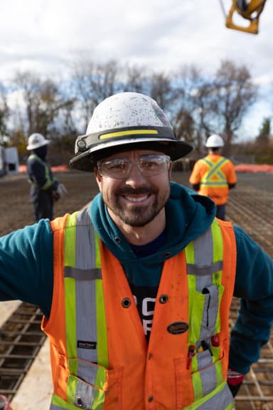 Employé de CSL Ltée posant de face avec un sourire avec une veste de sécurité orange