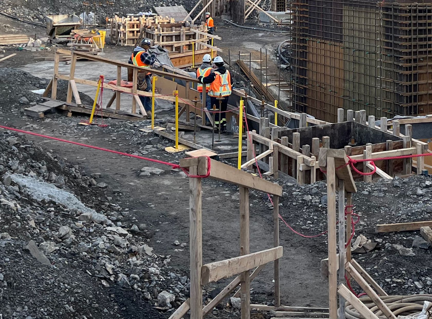 Travaux de coffrage et de bétonnage réalisés par une équipe sur un chantier industriel, avec passerelles temporaires et mesures de sécurité en place réalisé par CSL Ltée