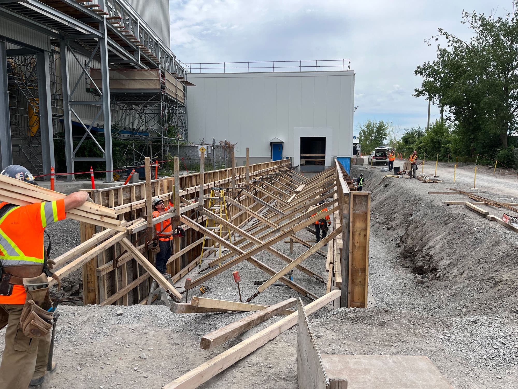 Construction de murs de soutènement en béton avec coffrage de bois sur un site industriel réalisé par CSL Ltée