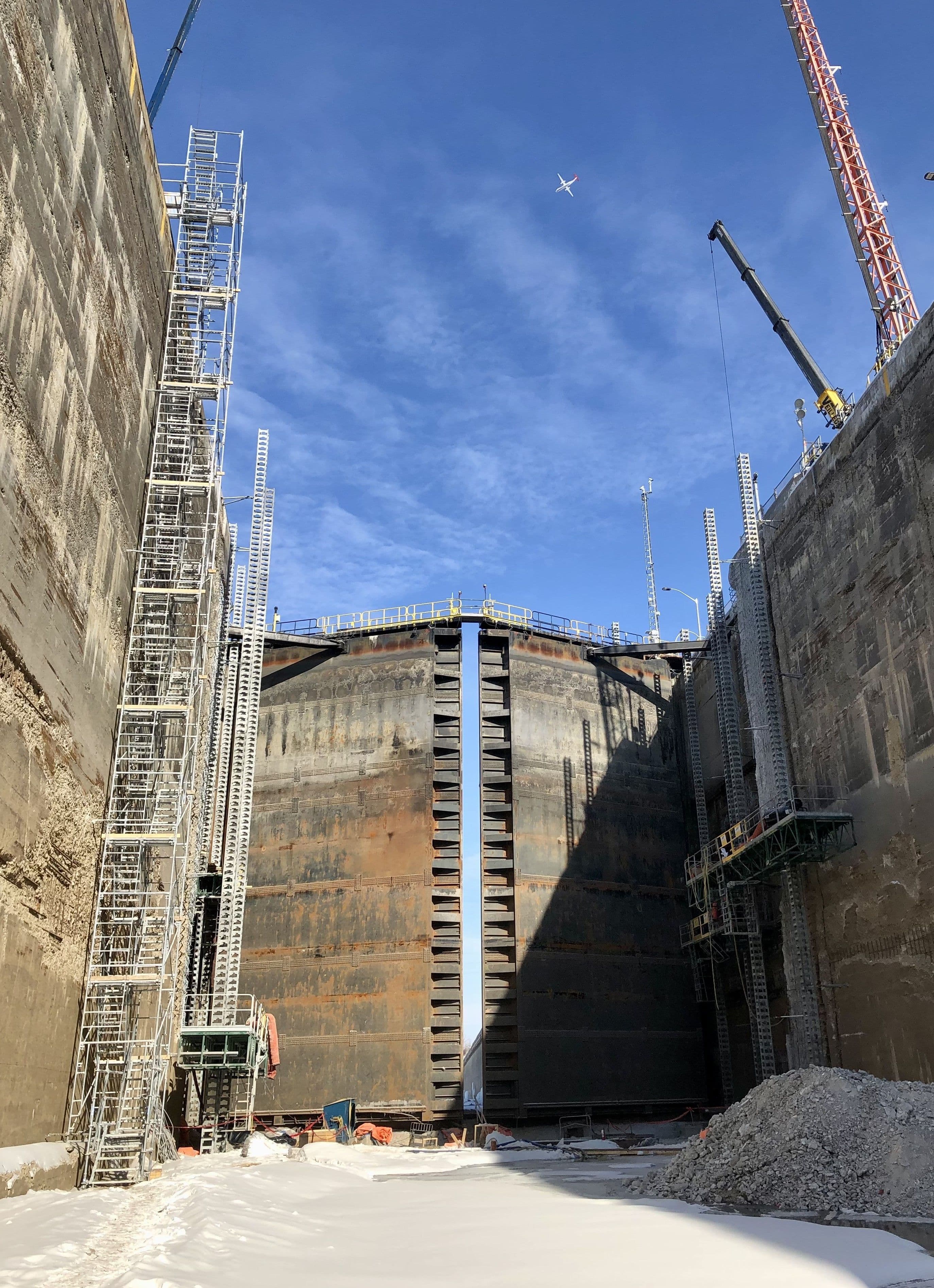 Chantier de génie civil lourd CSL Ltée : réfection des parois de béton d'une écluse avec échafaudages complexes et grue en conditions hivernales.