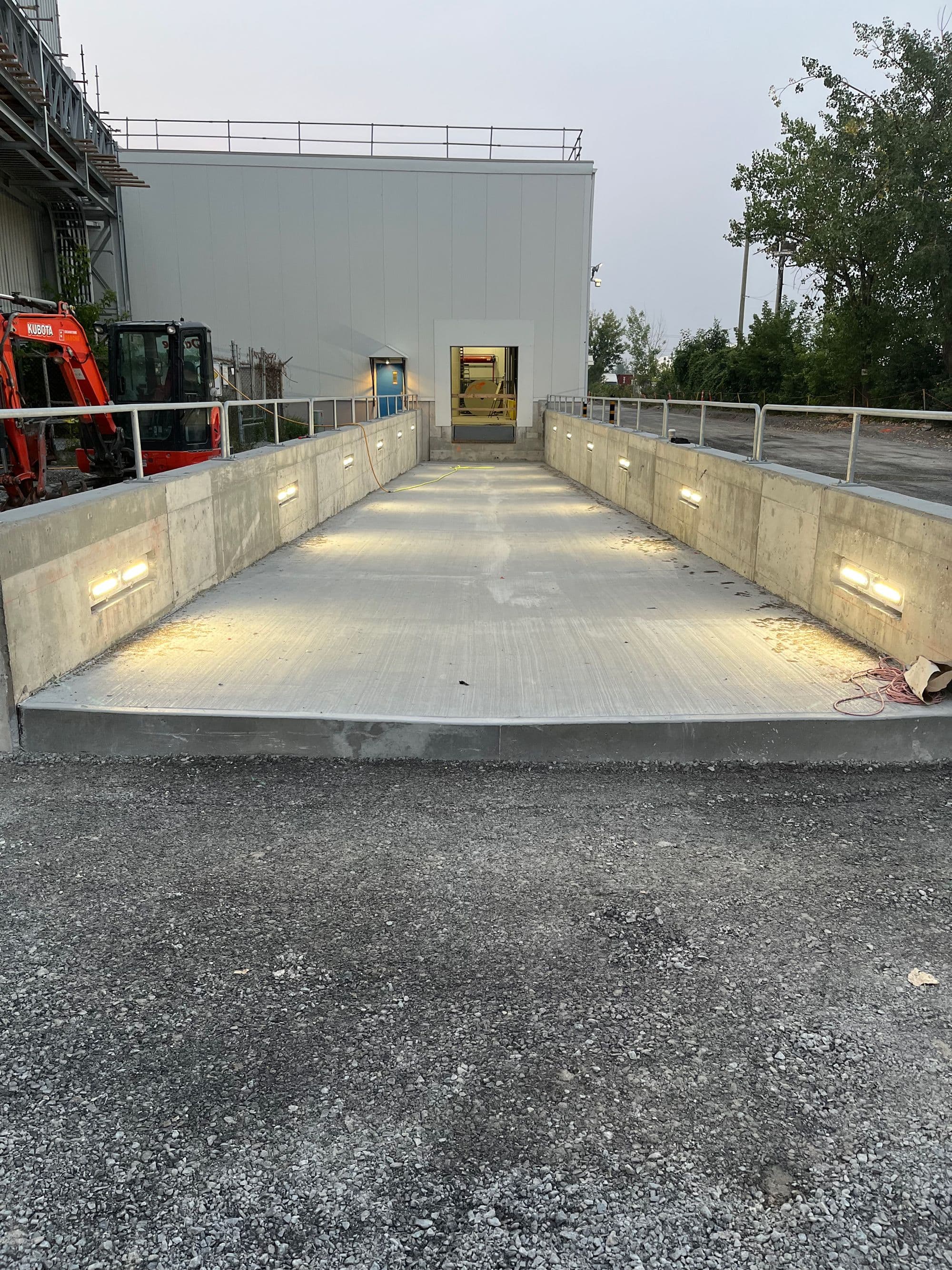 Rampe de béton neuve menant à un bâtiment industriel, réalisée lors de travaux d’infrastructures réalisé par CSL Ltée
